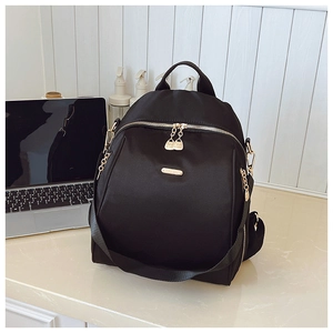 Detail of waterproof black nylon backpack with durable golden metal zippers and top handle