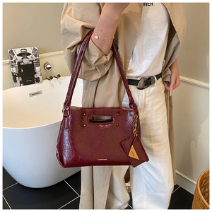 Detail of burgundy vintage textured PU leather handbag with matching coin purse charm
