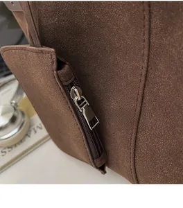 Detail of smooth metal zipper and premium stitching on coffee brown suede tote bag