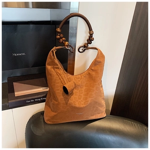 Détail du sac hobo à imprimé léopard avec anse décorée de perles en bois marron