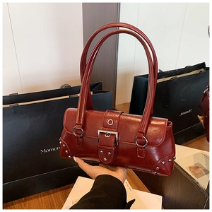 Détail du sac à bandoulière en cuir ciré bordeaux avec boucles et rivets argentés