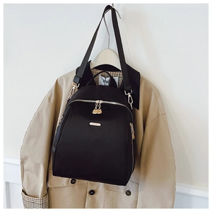 Detailed view of black oxford fabric backpack with premium gold metal zippers and hardware