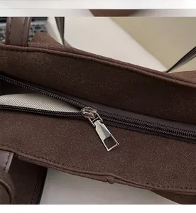 Close-up of smooth metal zipper and durable herringbone fabric lining on brown tote bag