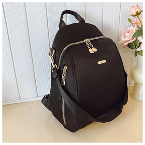 Close-up of black oxford backpack featuring premium gold zippers and metal logo detail