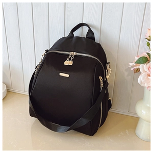 Detailed view of high-density waterproof black nylon backpack with light gold metal zippers