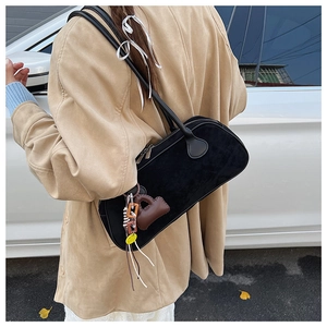 Detail view of retro matte black bowling bag with decorative charms on shoulder strap