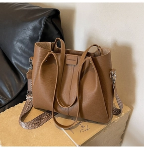 Brown lychee texture leather tote bag with stylish geometric woven shoulder strap