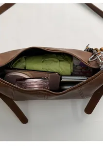 Detailansicht der braunen Ledertasche mit Darstellung der großen Speicherkapazität