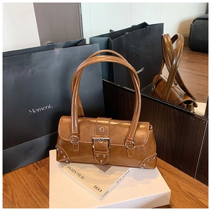 Détails du sac porté épaule en cuir ciré marron avec boucles argentées et rivets