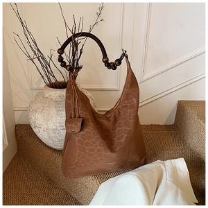 Vue détaillée de la texture léopard et de la poignée ronde perlée du sac hobo