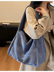 Minimalist blue denim hobo bag with wide black strap and large capacity for daily commute