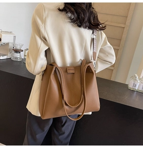 Brown leather tote bag detail with woven shoulder strap in a modern cafe setting