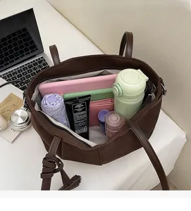 Macro view of the large capacity tote bag interior showing laptop, umbrella and essentials