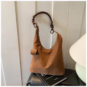 Détail du sac cabas léopard avec poignée en perles de bois rondes sur finition suédine