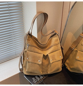 Detail der khakifarbenen Canvas-Tasche mit Funktionstaschen und silbernen Beschlägen