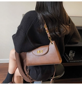 Détail du sac porté épaule vintage marron avec chaîne dorée et fermoir métallique