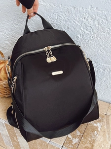 Waterproof black nylon backpack with gold zippers and metal logo for travel and school