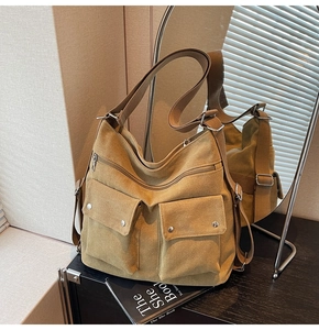 Detailansicht der senfgelben Canvas-Tragetasche mit Vordertaschen und verstellbarem Gurt