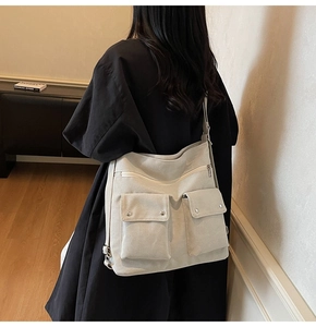 Detail of canvas tote bag with dual front cargo pockets and zipper on a female model