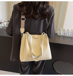Detail of cream tote bag featuring lychee texture and bohemian geometric strap