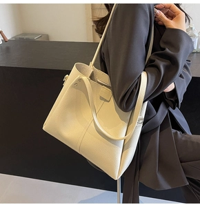 Detail of cream pebbled leather tote bag showing spacious capacity and soft texture