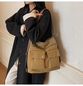 Detail der khakifarbenen Canvas-Tasche mit funktionellen Taschen und Textur