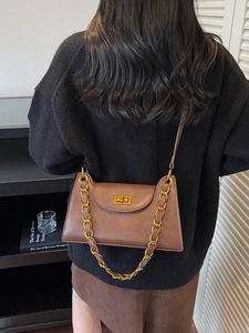 Sac à bandoulière vintage marron avec chaîne dorée et fermoir à rabat sur modèle