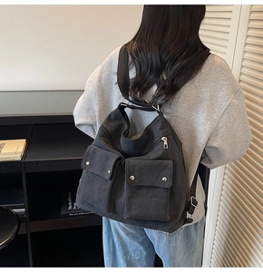 Detailansicht des schwarzen Canvas-Utility-Rucksacks mit mehreren Taschen und Silberbeschlägen