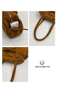 Détail du sac polochon en daim caramel montrant la poche latérale et la fermeture à glissière