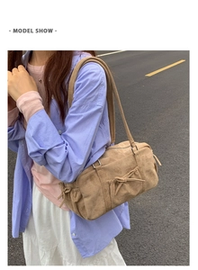 Vue street style d'un sac hobo en daim kaki avec nœuds décoratifs et longues lanières