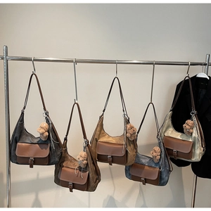 Dettaglio di borse hobo in tela lavata con tasche in pelle e ciondoli a forma di orso