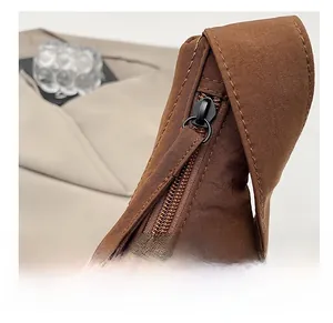 Close-up of smooth metal zipper and durable nylon fabric on the brown dumpling bag