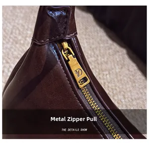 Close-up of vintage gold hardware zipper and detailed stitching on dark brown leather
