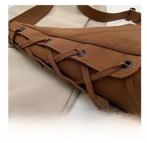 Detail view of the brown nylon crossbody bag with stylish drawstring and matte eyelets