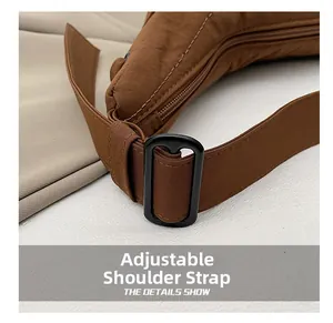 Detailed close-up of the adjustable shoulder strap and buckle on the brown dumpling bag