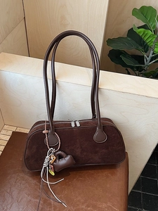 Retro dark brown matte bowling bag with long handles and heart pendant shown in a warm studio