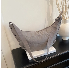 Detail of grey dumpling bag showing lace-up side design and nylon fabric texture