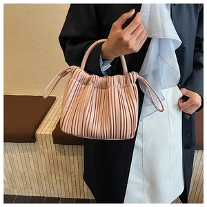 Detail of pink pleated bucket bag with soft ruched texture and delicate side drawstring