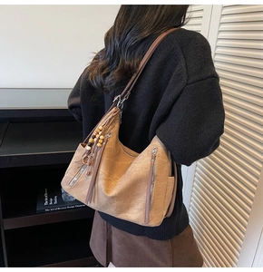 Detail of vintage brown leather hobo bag with tassel and side zipper on model