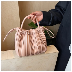 Detailed close-up of pink pleated bucket bag with soft gathered texture and drawstring