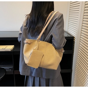 Detail view of beige suede tote bag with adjustable silver buckle and small hanging pouch