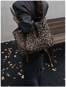 Macro view of leopard print tote bag showing thick canvas texture and faux leather straps