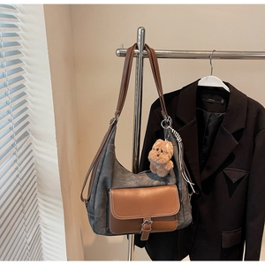 Dettaglio della borsa tote in tela grigia con tasche in pelle e ciondolo a forma di cane