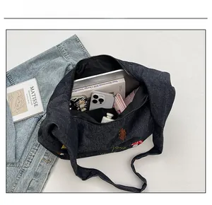 Détail de l'intérieur du sac en jean bleu montrant sa grande capacité de rangement