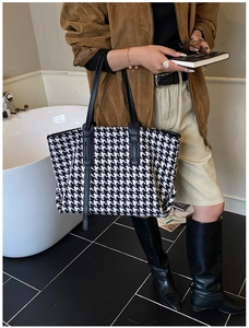 Detail of houndstooth tote bag showing large capacity and black leather handles