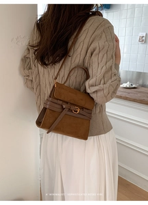 Detalle del bolso de ante marrón con hebilla de metal vintage y textura de la correa