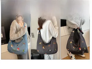 Détail du sac cabas en toile brodée montrant les motifs floraux et les styles de transport