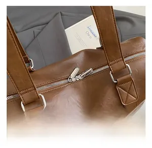 Detailed close-up of premium silver hardware and reinforced stitching on a brown tote bag