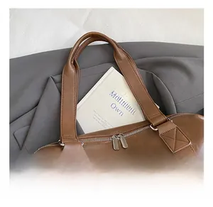 Close-up of comfortable reinforced handle and premium metal zippers on brown leather bag