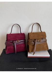 Detalle de bolsos de gamuza granate y tostado con elegantes correas de hebilla de metal
